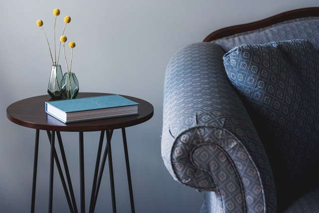 Sofa Arm And End Table With Flowers On It